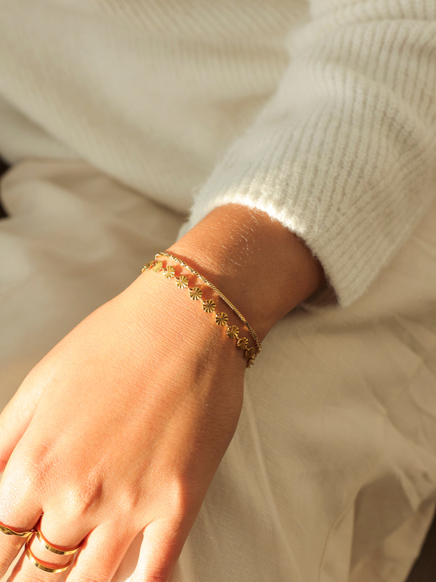 Feine Armkettchen und Ringe am Handgelenk mit Strickpullover-Ärmel – Schmuck für Gastgeberinnen