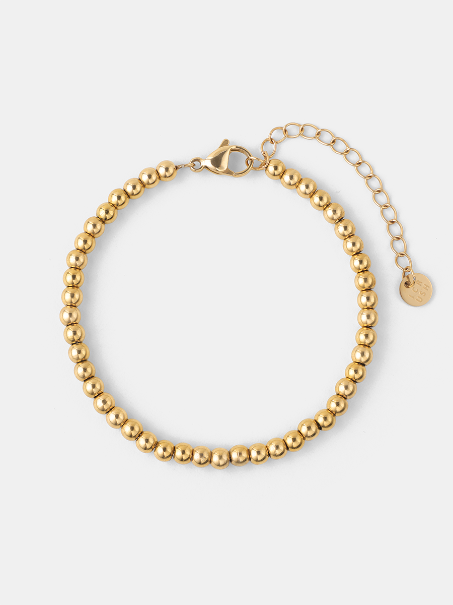 Goldfarbenes Kugelketten-Armband mit Karabiner, Verlängerungskette und rundem Anhänger auf weißem Hintergrund.