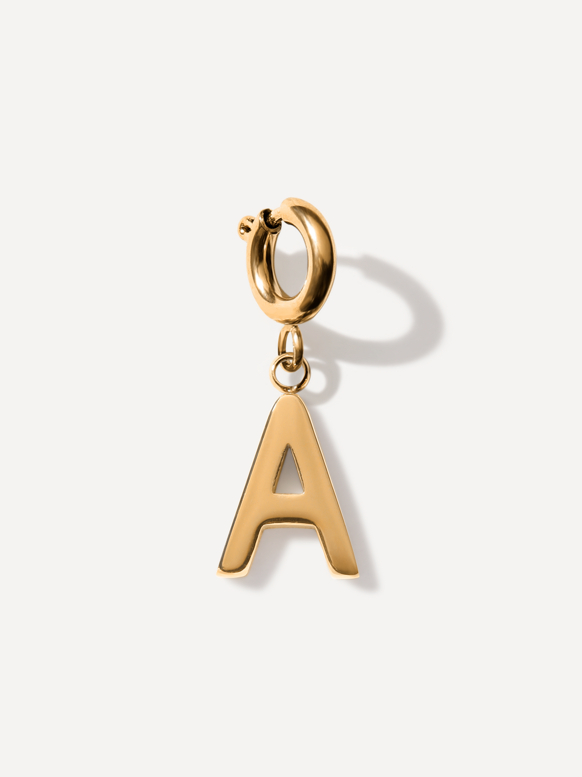 Goldener Buchstaben-Anhänger A mit Ösenring und glänzender Metalloberfläche vor weißem Hintergrund.