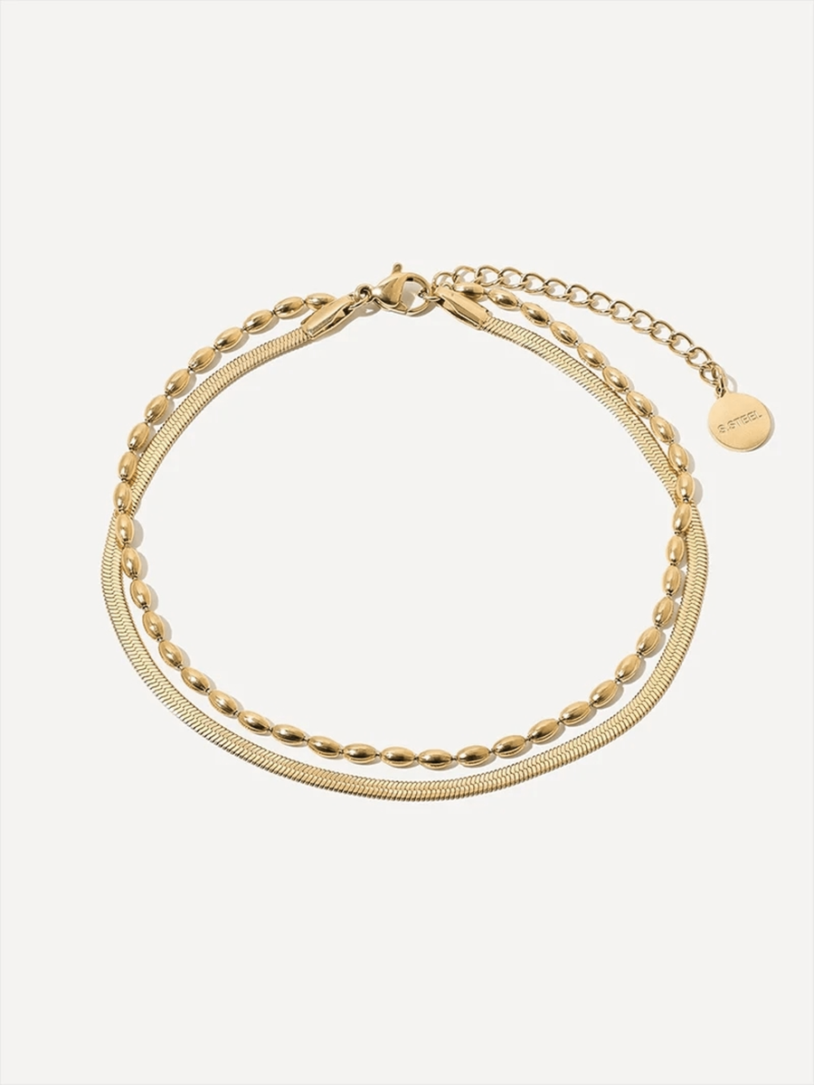 Goldfarbenes Fußkettchen mit zwei Lagen: Schlangenkette, ovale Gliederkette, Karabiner, Verlängerung und Anhänger.