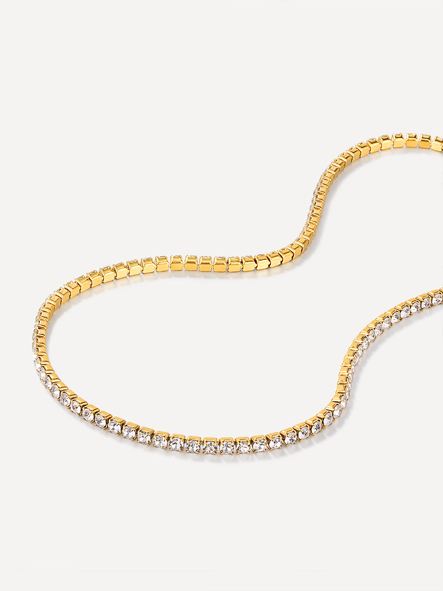 Goldene Halskette mit rechteckiger Boxkette und funkelnder Tennis-Kette auf hellem Hintergrund.