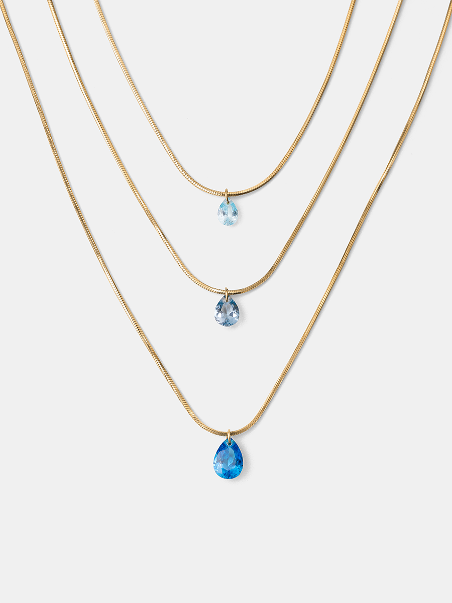 Goldene dreireihige Halskette mit drei Schlangenketten und je einem blauen Tropfenanhänger als Packshot.