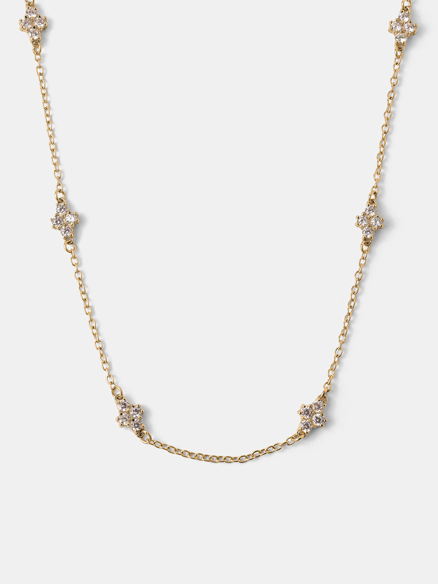 Goldene Gleaming Delight Halskette mit zarten Kleeblatt-Anhängern und feiner Gliederkette auf weißem Grund.