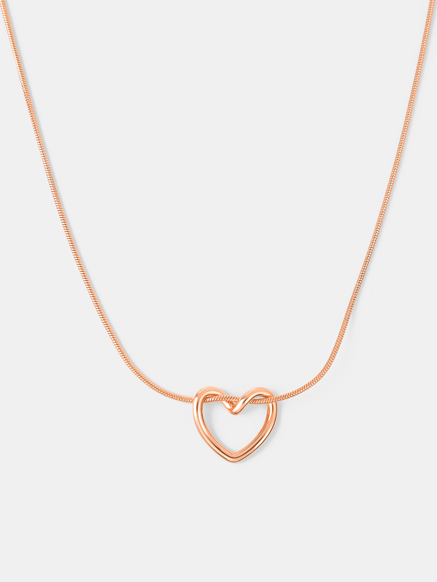 Roséfarbene Herz-Kette mit glänzendem Anhänger, zarter Schlangenkette, neutraler Hintergrund.