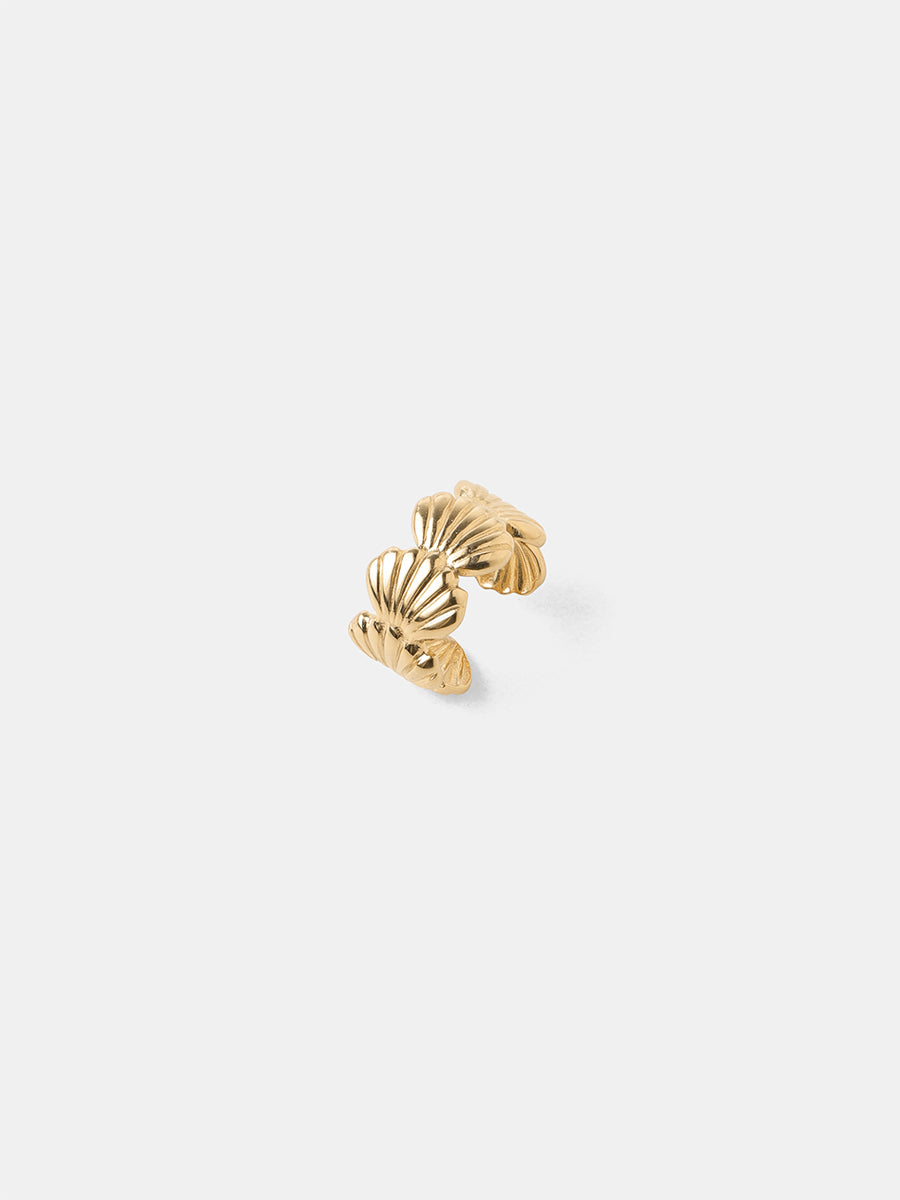 Goldener, geschwungener Earcuff mit Muschelrelief und offenem Ende, freigestellt auf weißem Grund.