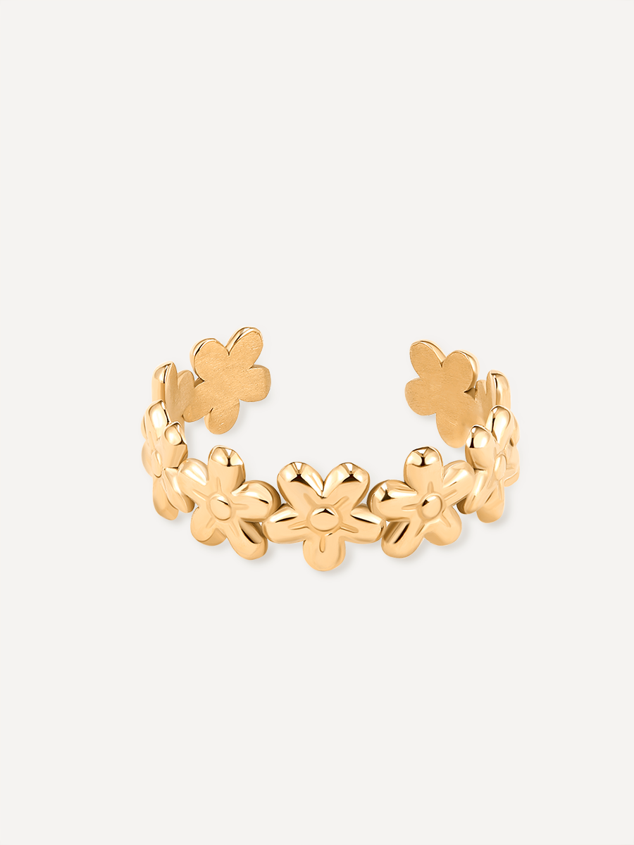 Goldfarbener Ring mit Blütenmotiv und offener Schiene, poliert, vor neutralem Untergrund.