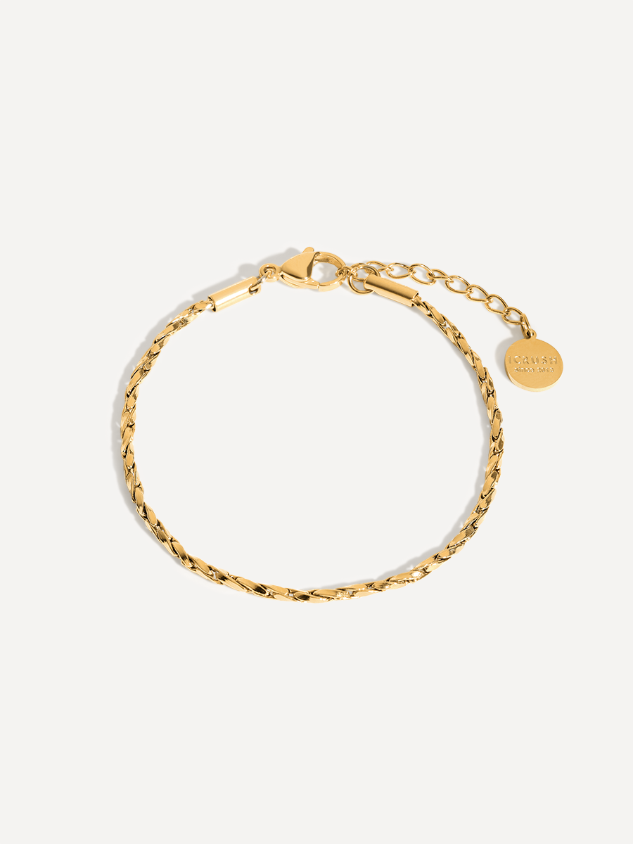 Goldenes Armband als runde Kette mit Karabiner, Verlängerung und Anhänger vor neutraler, heller Fläche.