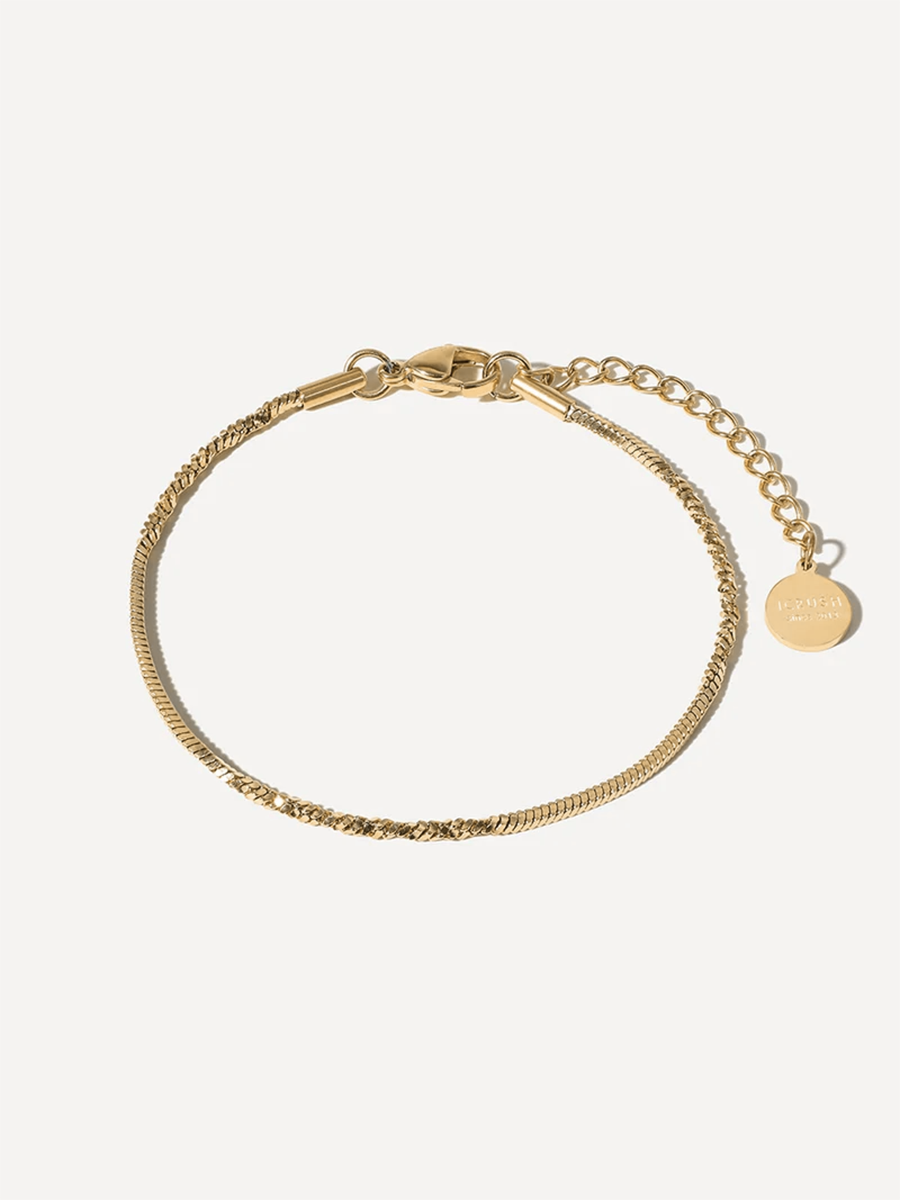 Goldene Gliederkette zum Armband gerundet, mit zarter Verlängerung und kleinem Markenanhänger.
