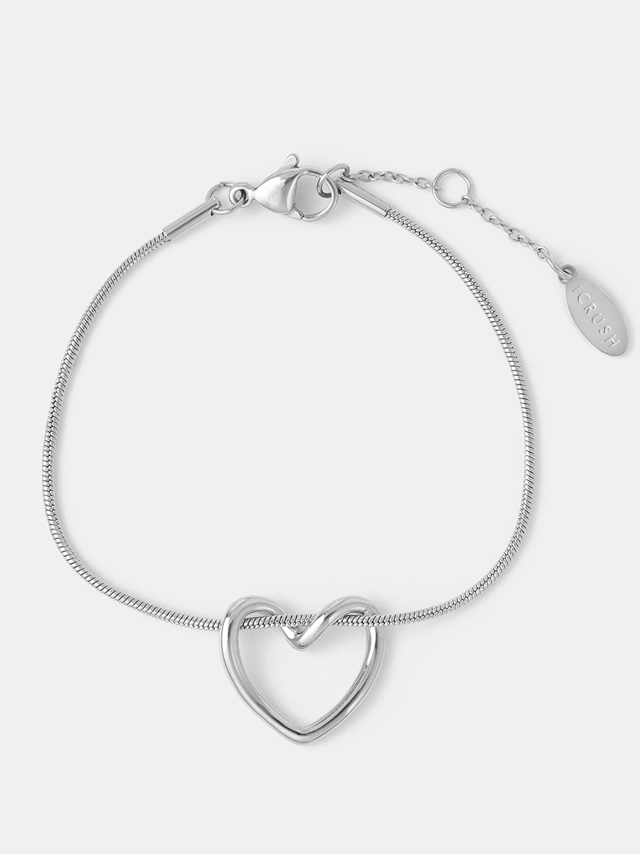 Silberner Armschmuck mit schlangenartiger Gliederkette, offenem Herzelement, Verschlusshaken und Kettchenverlängerung, flach liegend.