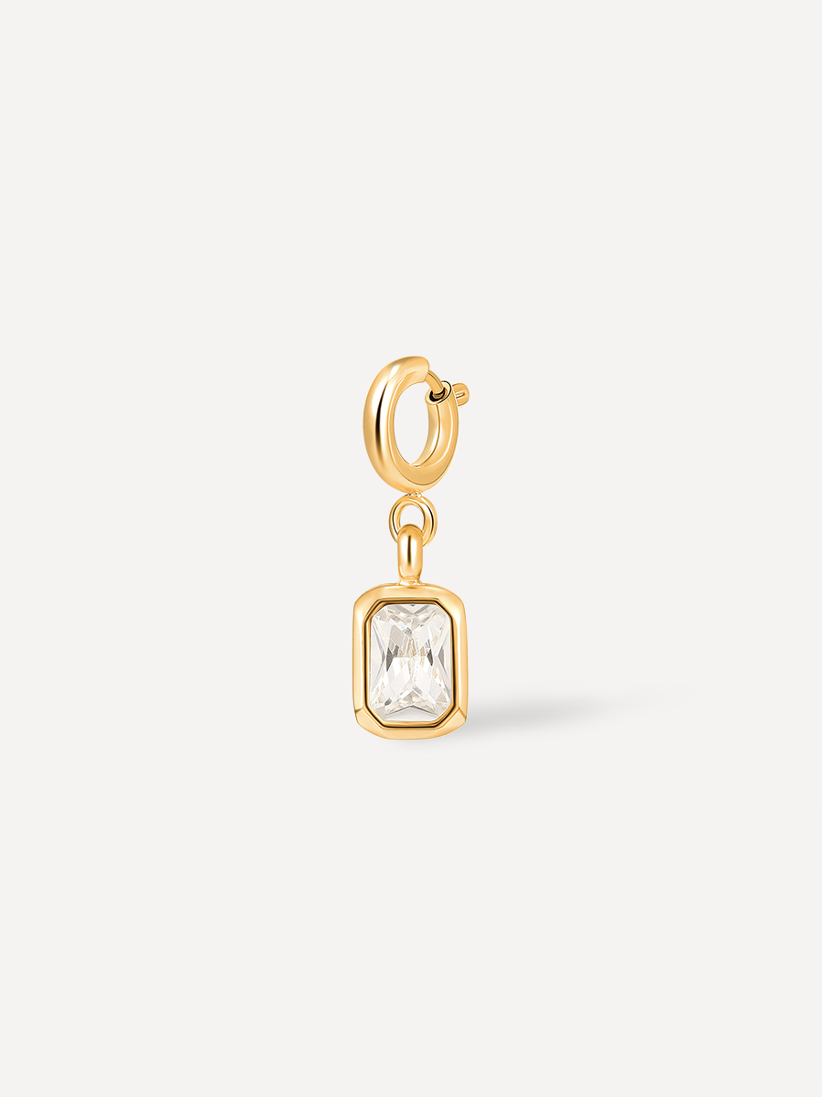 Goldener Kettenanhänger mit klarem Rechteckstein und Befestigungsring, frontal auf hellem Grund.