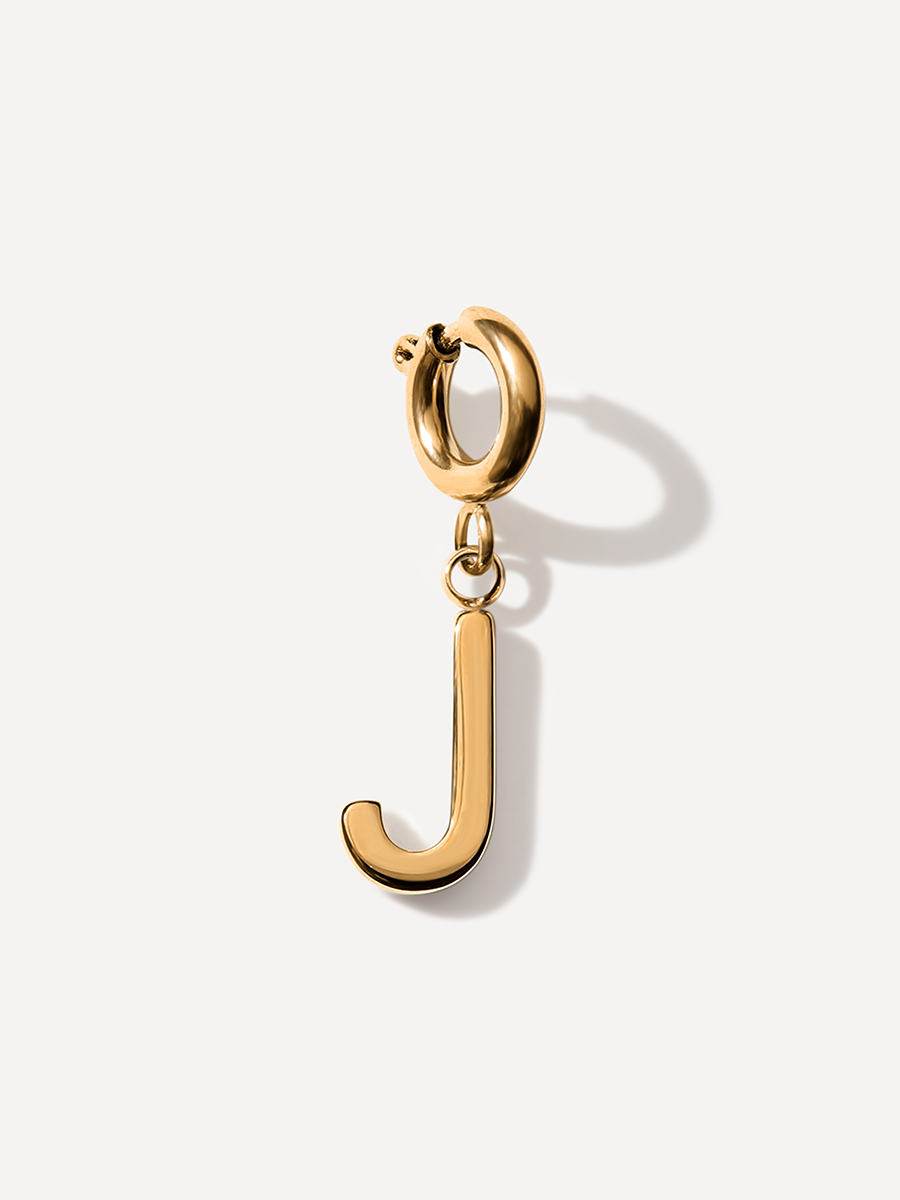 Goldener Ketten-Charm J mit rundem Verschlussring, polierter Oberfläche und Schattenwurf.