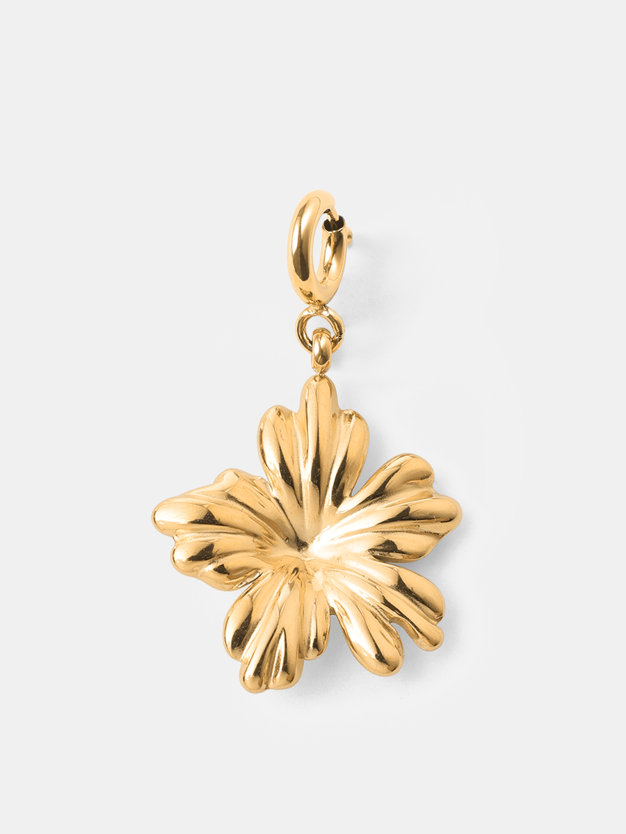 Goldfarbener Blüten-Charm mit Karabiner, glänzend, vor schlichtem hellem Hintergrund.