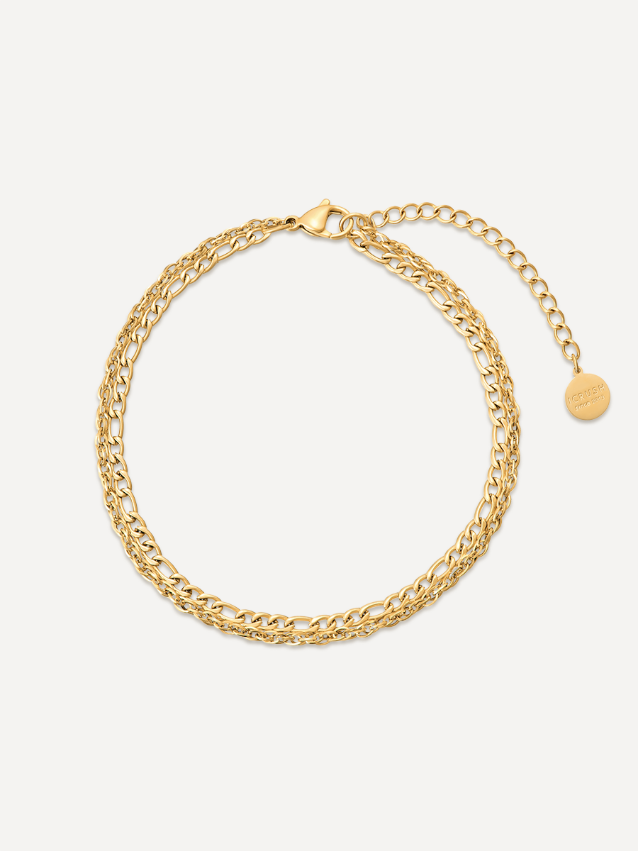 Rund gelegtes goldfarbenes Fußkettchen mit Kettengeflecht, Karabiner und kleinem Münzanhänger vor neutralem Untergrund.
