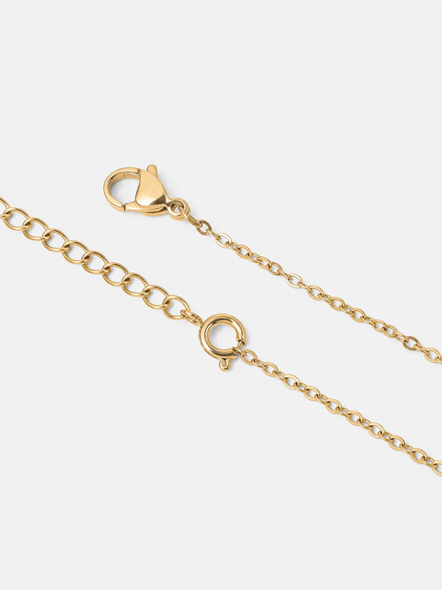 Goldene Gliederkette im Detail, diagonal, mit Verschluss, Zwischenring und Verlängerungskettchen.