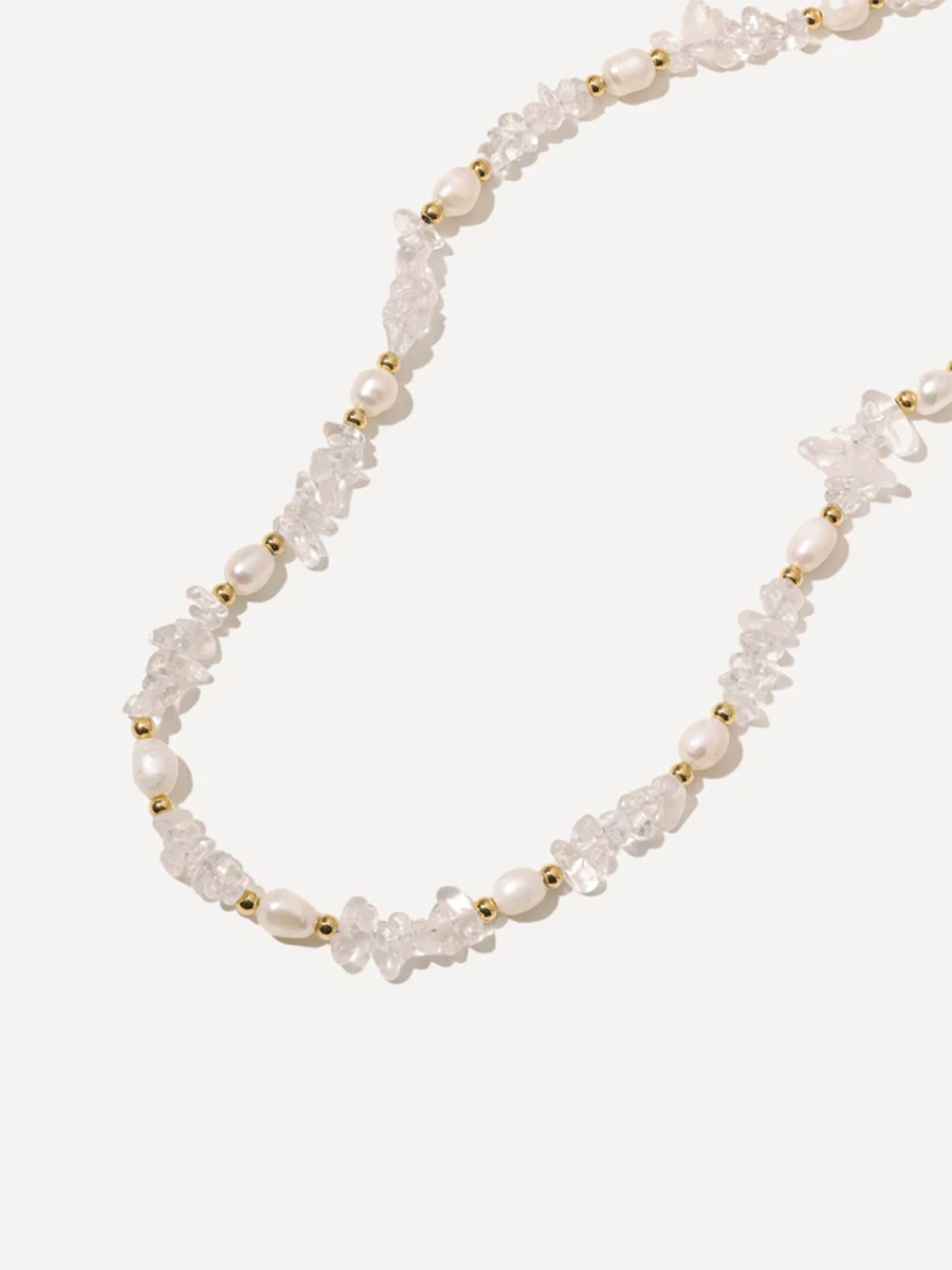 Perlenschmuck mit unregelmäßigen weißen Perlen, klaren Steinen und goldfarbenen Zwischenperlen.