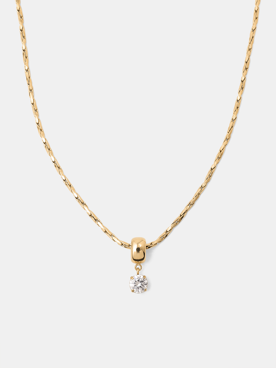 Goldene Halskette mit rundem Klarstein, kurzer Aufhängung und einfarbig weißem Hintergrund.