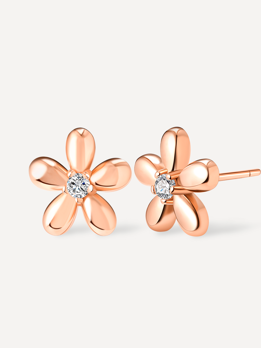 Roséfarbenes Ohrsteckerpaar in Blumenform, fünf Blütenblätter, klarer Stein, eine Nadel seitlich sichtbar auf hellem Untergrund.