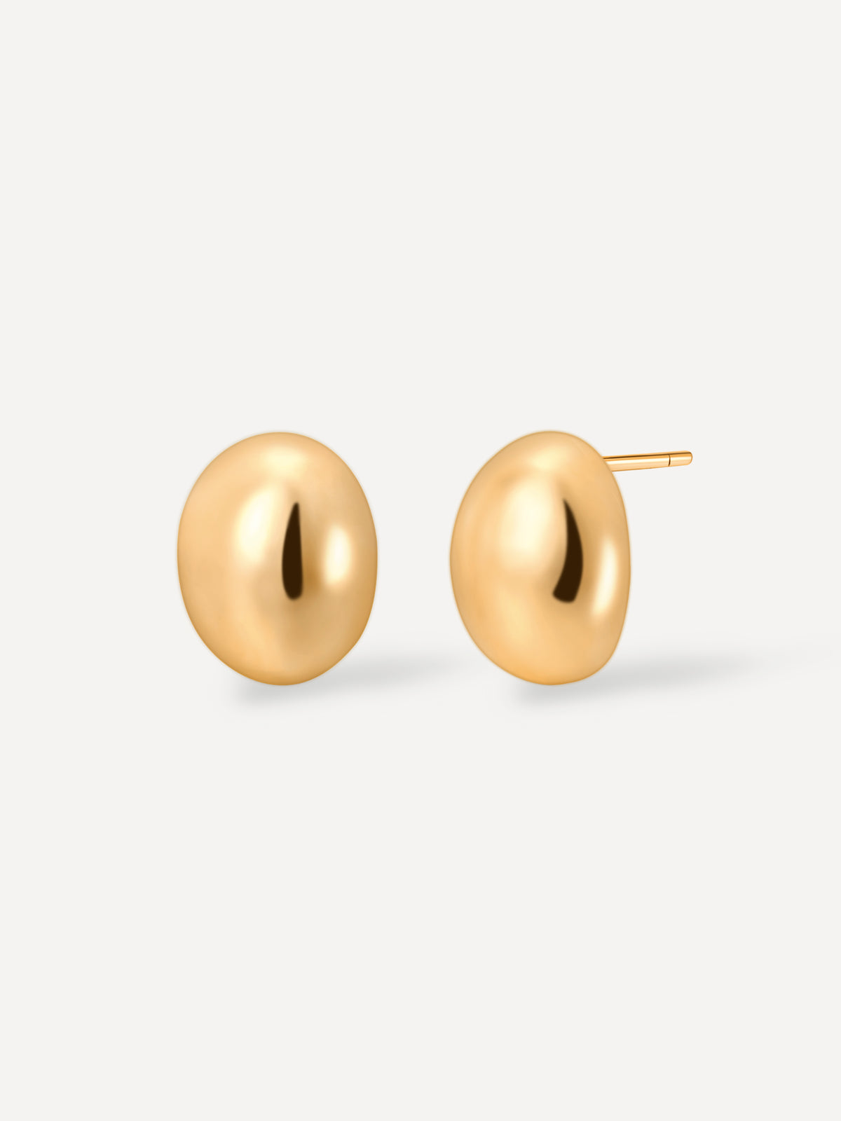 Goldglänzende Bohnen-Ohrstecker als Paar auf weißem Untergrund, einer präsentiert den Stecker.