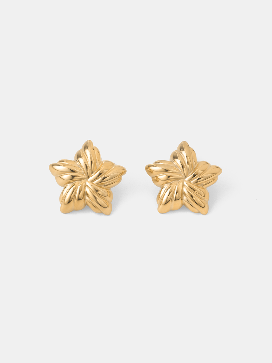 Zwei goldfarbene Blütenohrstecker präsentieren sich nebeneinander, glänzende Metalloptik und plastisches Blütenrelief vor schlichtem Weiß.